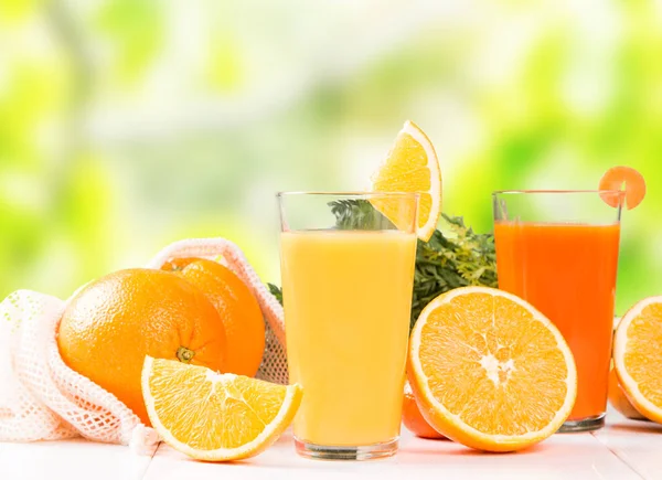 Fresh juice, orange drink with fresh fruits on wooden table.