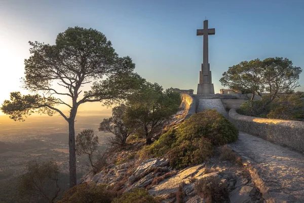 Santuari de sant salvador, grande cruz em uma colina ao pôr do sol com belo céu colorido, Felanitx, Maiorca, Espanha — Fotografia de Stock