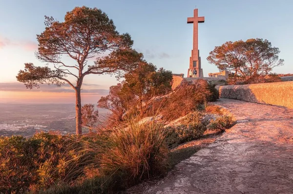 Gün batımında Sant Salvadorat 'un kesiştiği yol ve ağaçlarla kaplı bir çift Felanitx, Mallorca, İspanya.
