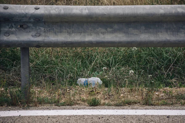 Çöp yerde yatıyordu. Yolun yanında plastik şişe var. Yeryüzündeki kirliliği kavrayın. Doğadaki pislik.