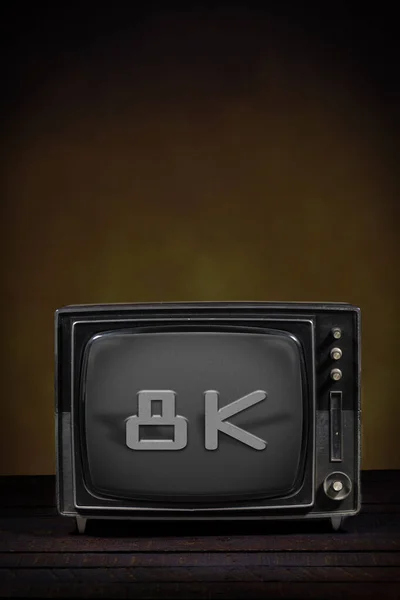 Old portable television, with text on the screen. Wooden table and brown background. Concept of obsolescence, modernization or technological revolution