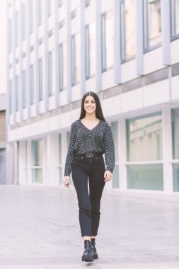 Modern ve gülümseyen genç kız ofis caddesinde yürüyor.