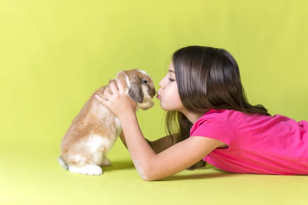 Menina Brincando Com Seu Coelho Estimação Deitado Chão Beijando Estúdio — Fotografia de Stock