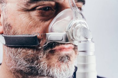Uyku bozuklukları için solunum maskesi takan yaşlı bir adam. Apne. Tıbbi cihazlar. Hava pompası. Destekli nefes alma