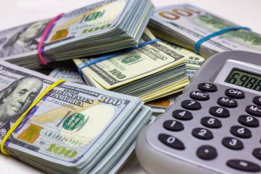 ABD Doları beyaz arka planda gri hesap makineli paketler. Para muhasebe ve finans tasarruf analizi kavramı.