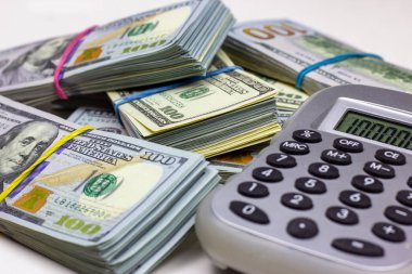 ABD Doları beyaz arka planda gri hesap makineli paketler. Para muhasebe ve finans tasarruf analizi kavramı.