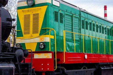 Tren istasyonundaki eski yeşil ve kırmızı dizel motor lokomotifi. Demiryolunda kalan klasik tren..