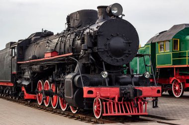 Tren istasyonundaki eski siyah ve kırmızı buharlı lokomotif. Demiryolunda kalan klasik tren.
