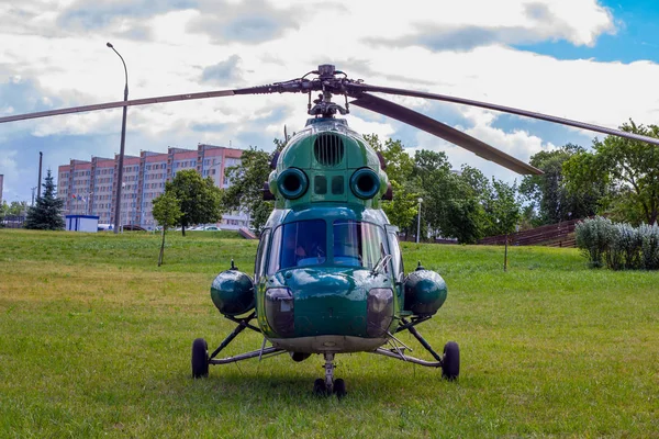 緑の軍用ヘリコプターが街の公園に着陸しています — ストック写真