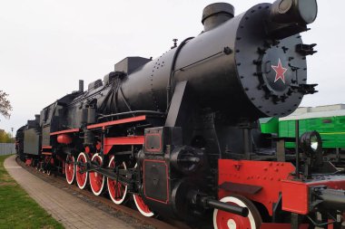 Tren istasyonundaki eski siyah ve kırmızı buharlı lokomotif. Demiryolunda kalan klasik tren.