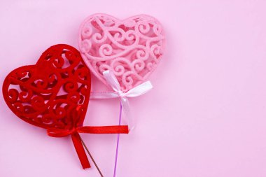Yumuşak romantik arka planda iki parlak kırmızı ve pembe renkli oyuncak kalp. Sevgililer Günü kutlamaları ve aşk konsepti.