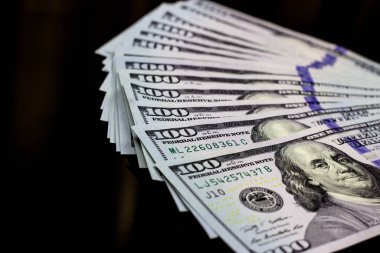 Yüz dolar siyah arka planda. Finans ve para kavramı.