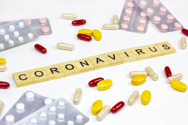 The medical phrase coronavirus with pills, capsules and tablets on light background. Ncov epidemic alert concept.
