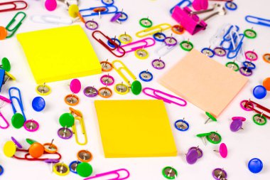 Ofis için parlak pembe, sarı, mavi ve yeşil kırtasiye aksesuarları ve beyaz arka planda eğitim için yapışkan notlarla kopyalama alanı.