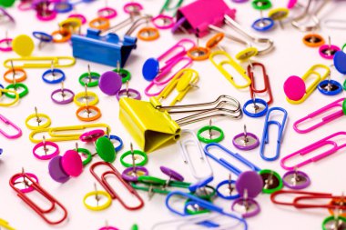 Ofis için açık pembe, sarı, mavi ve yeşil kırtasiye aksesuarları ve beyaz arka planda eğitim.