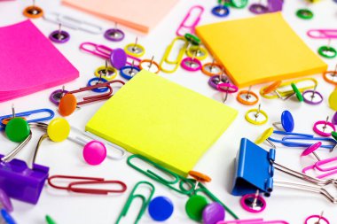 Ofis için parlak pembe, sarı, mavi ve yeşil kırtasiye aksesuarları ve beyaz arka planda eğitim için yapışkan notlarla kopyalama alanı.