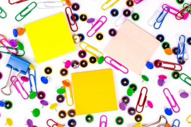 Ofis için parlak pembe, sarı, mavi ve yeşil kırtasiye aksesuarları ve beyaz arka planda eğitim için yapışkan notlar kopyalama alanı.