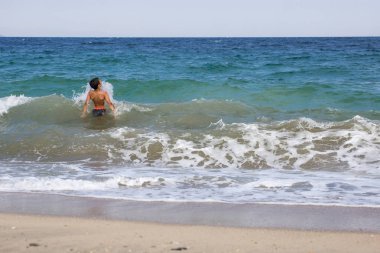 Sıçramasına ve mutlu Yüzme, dalgalar ile oynayan heyecanlı çocuk 