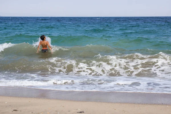 Sıçramasına ve mutlu Yüzme, dalgalar ile oynayan heyecanlı çocuk 