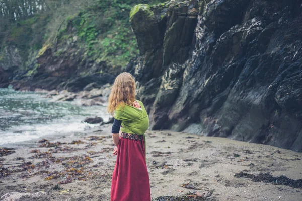 Una Giovane Madre Sulla Spiaggia Con Suo Bambino Una Fionda — Foto Stock