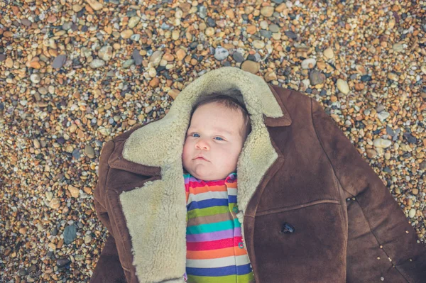 Ένα Μικρό Μωρό Είναι Τυλιγμένο Ένα Παλτό Στην Παραλία — Φωτογραφία Αρχείου