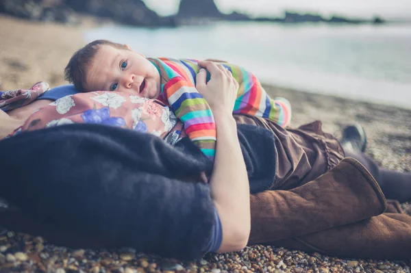 Madre relajándose en la playa con el bebé — Foto de Stock
