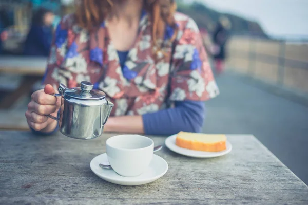 女性が外お茶を注ぐ — ストック写真