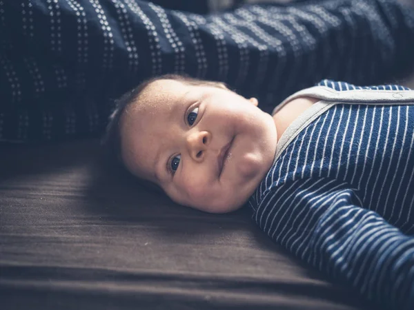 Söt liten bebis på en säng — Stockfoto