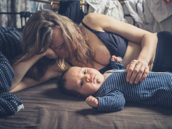 그의 어머니와 함께 침대에 귀여운 아기 — 스톡 사진