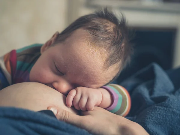 Sovande baby på mammas bröst — Stockfoto