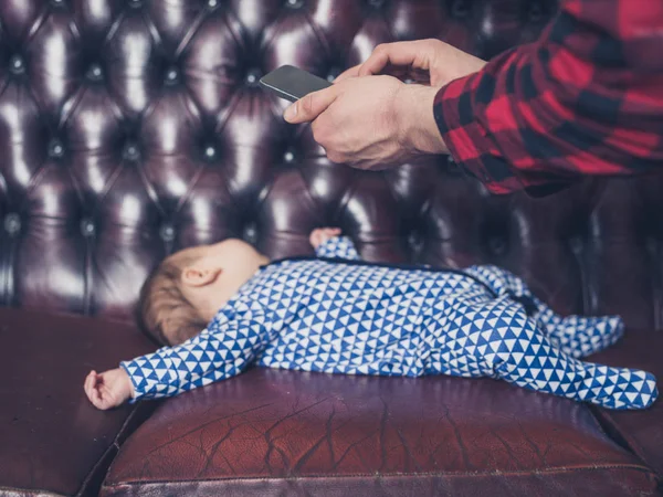 Людина фотографує сплячого дитини — стокове фото