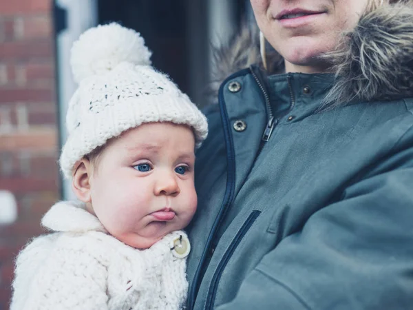 Mother with baby outside house in winter — Stock Photo, Image