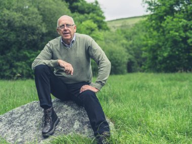 Üst düzey bir adam bir doğada bir yaz gününde dinleniyor