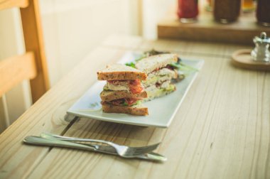 Bir tablo bir bacon marul domates sandviç ile bir kafede bir tabağa