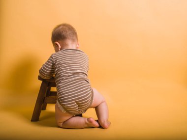 Küçük bir bebek bir tabure kullanarak durmaya öğrenme