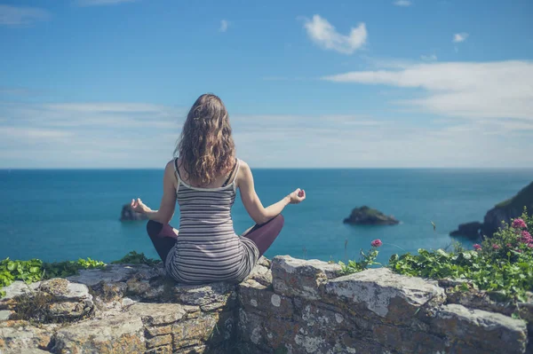 Genç Bir Kadın Bir Duvara Denizin Kenarında Oturan Meditasyon Yapıyor — Stok fotoğraf