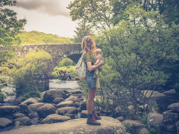 Молода Мати Стоїть Річці Біля Стародавнього Мосту Своєю Дитиною Слінгу — стокове фото