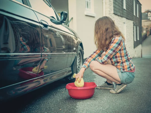 若い女性はソーピングと彼女の車を洗う — ストック写真