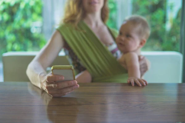 Young Mother Her Baby Sling Using Her Smartphone — Stock Photo, Image