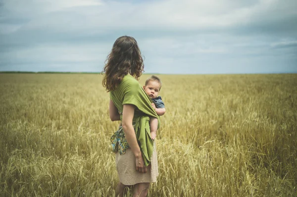 Una Giovane Madre Con Suo Bambino Una Fionda Piedi Campo — Foto Stock