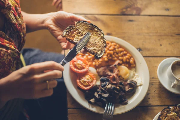 Молодая Женщина Разбрасывает Масло Тосте Рамках Традиционного Английского Завтрака — стоковое фото