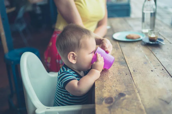Una Madre Está Ayudando Bebé Beber Una Taza Junto Ventana — Foto de Stock
