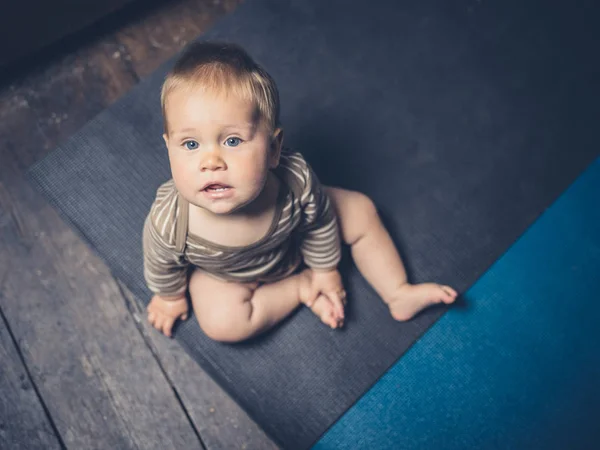 Lilla bebis sitter på yogamattor — Stockfoto