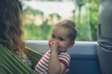 Trende askı içinde bebek ile anne