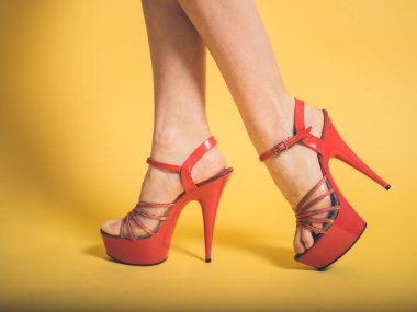 Woman in red stripper heels on yellow clipart