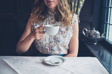 Kadın kahve içme pencere tarafından masada