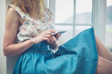 Telefonunu kır evi pencere tarafından kullanan kadın