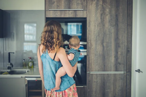 Mère avec bébé dans la cuisine — Photo