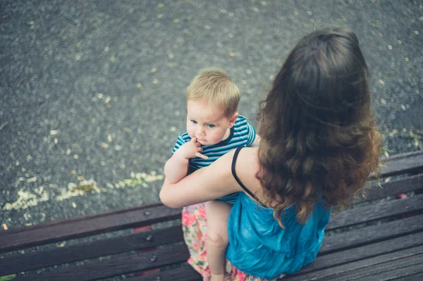 Madre con bebé en el banco del parque — Foto de Stock