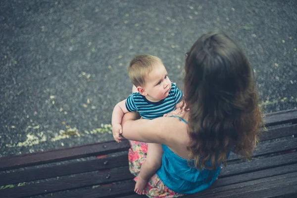 Mother with baby on park bench — Stock Photo, Image